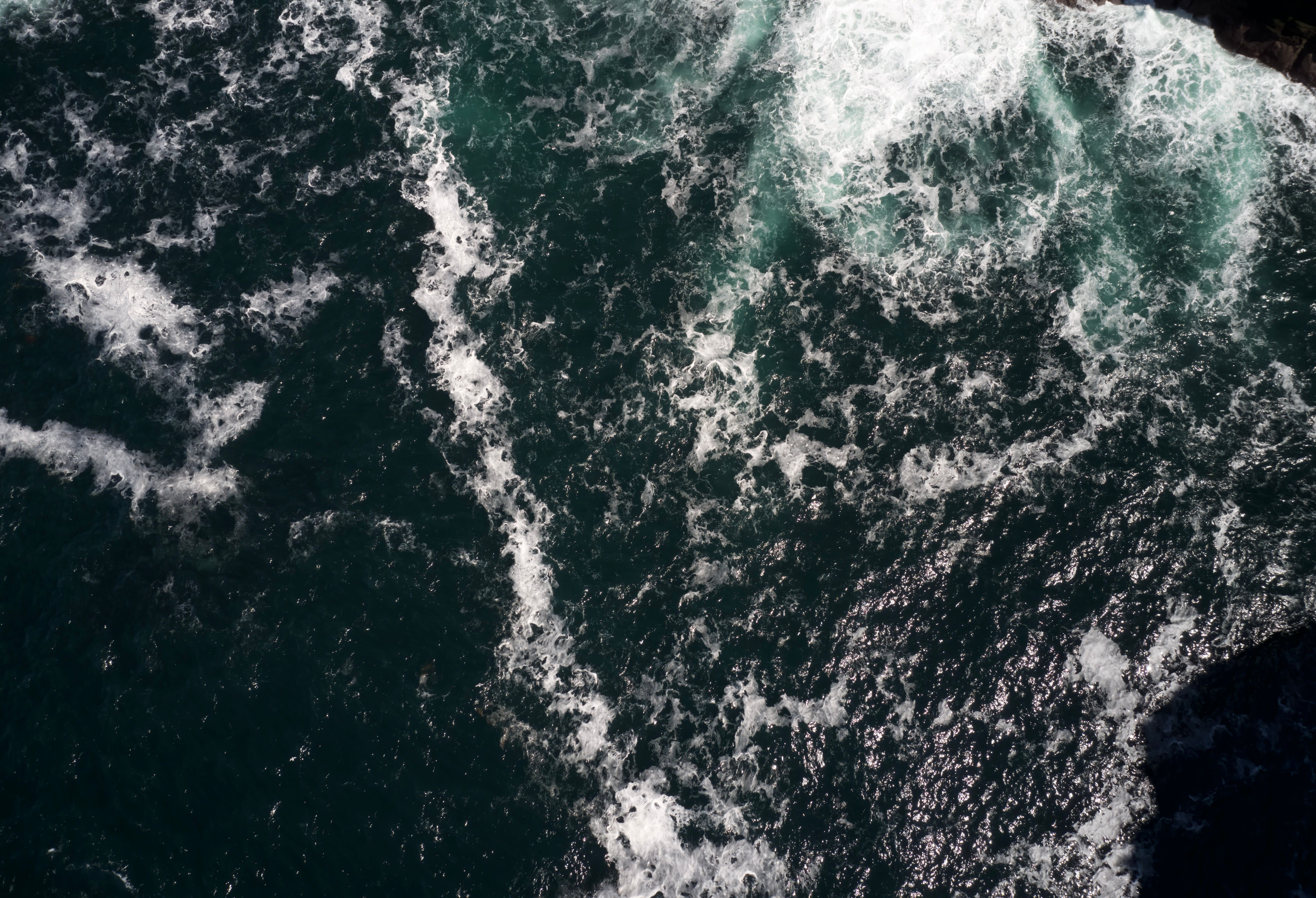 A breathtaking aerial shot capturing the dynamic texture and movement of ocean waves crashing.