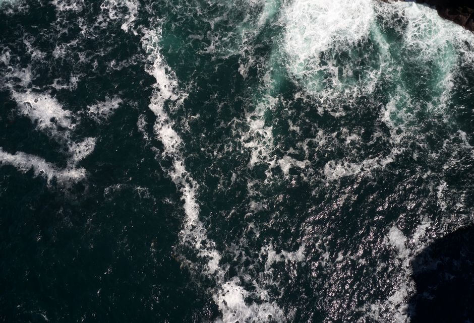 A breathtaking aerial shot capturing the dynamic texture and movement of ocean waves crashing.
