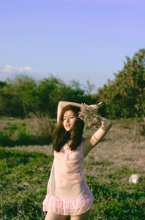 Woman Wearing Pink Dress Standing on Flower Garden