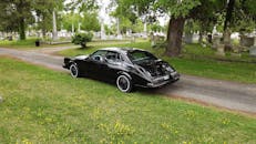 在弗吉尼亚州诺福克一座旧墓地的宁静小路上，停着一辆经典的黑色汽车