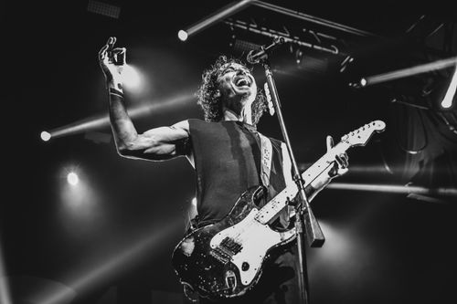 Free Black and white photo capturing an energetic guitarist performing live on stage. Stock Photo