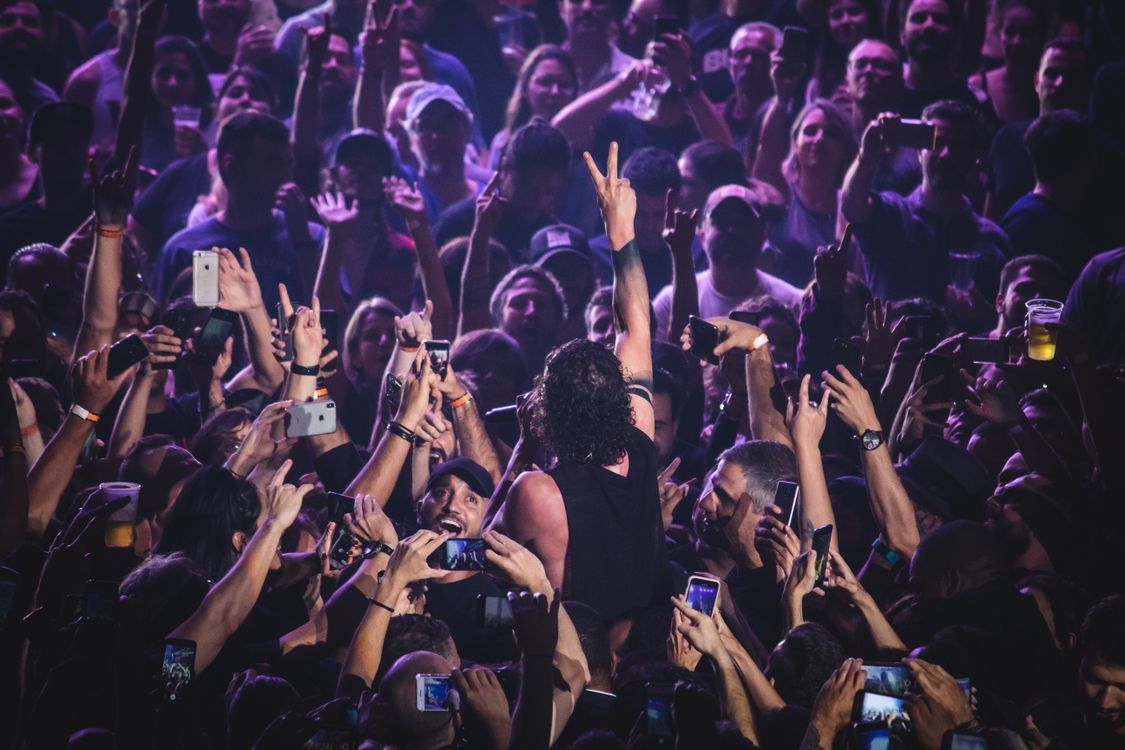 Free Vibrant crowd at a live concert with a performer engaging the audience, creating an electric atmosphere. Stock Photo