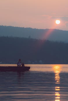 一对母女坐在码头上，静静地看着肖尼根湖上的日落