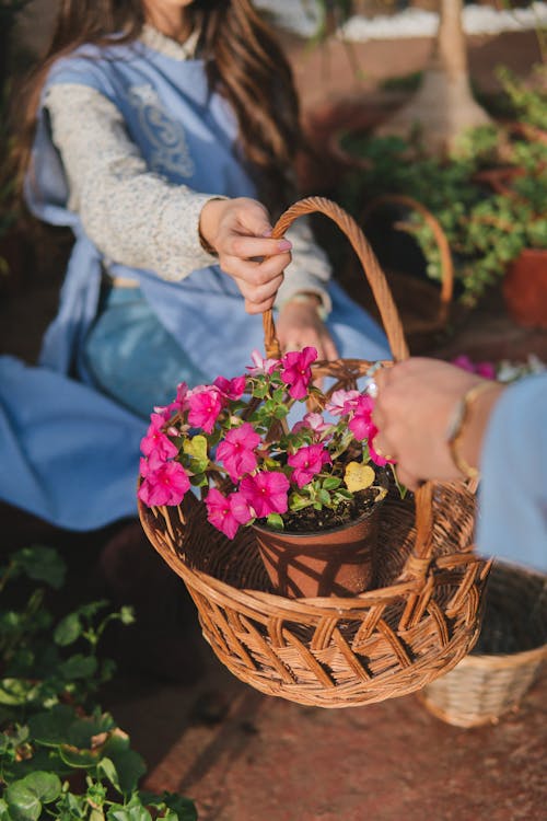 中に赤い花びらの花と籐のバスケットを保持している2人