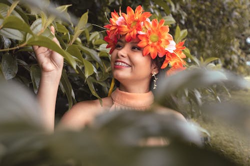 無料 オレンジ色の花の頭飾りを身に着けている笑顔の女性 写真素材