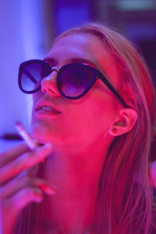 Close-up Photo of Woman in Sunglasses Smoking a Cigarette