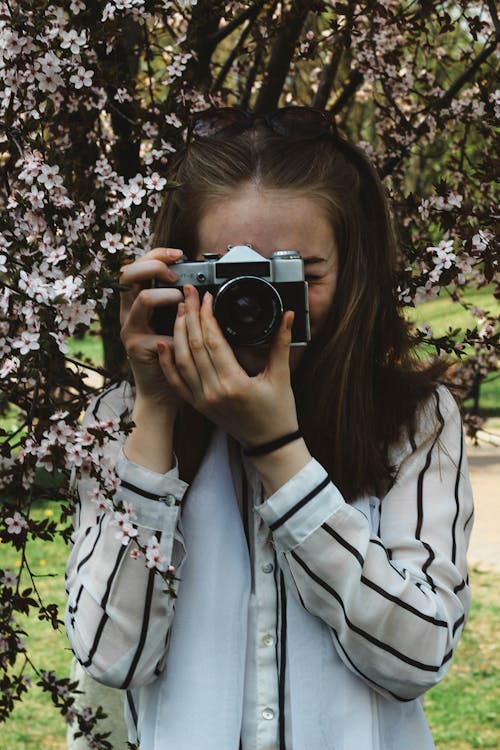 Young Woman Taking Photo using Analog Camera