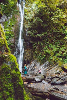 母女俩在温哥华岛郁郁葱葱的森林中，欣赏着风景如画的瀑布