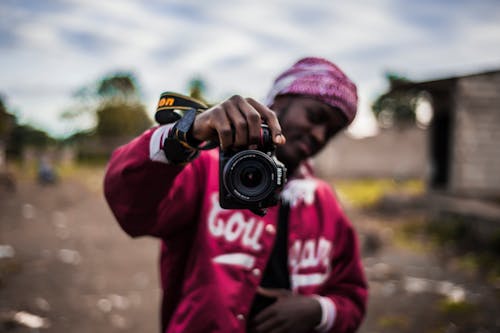 Orang Yang Memegang Kamera Dslr Hitam Dalam Fotografi Fokus Selektif