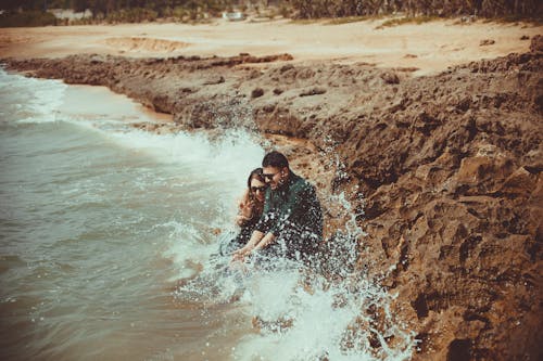 Hombre Y Mujer, Sentado, En, Orilla Del Mar