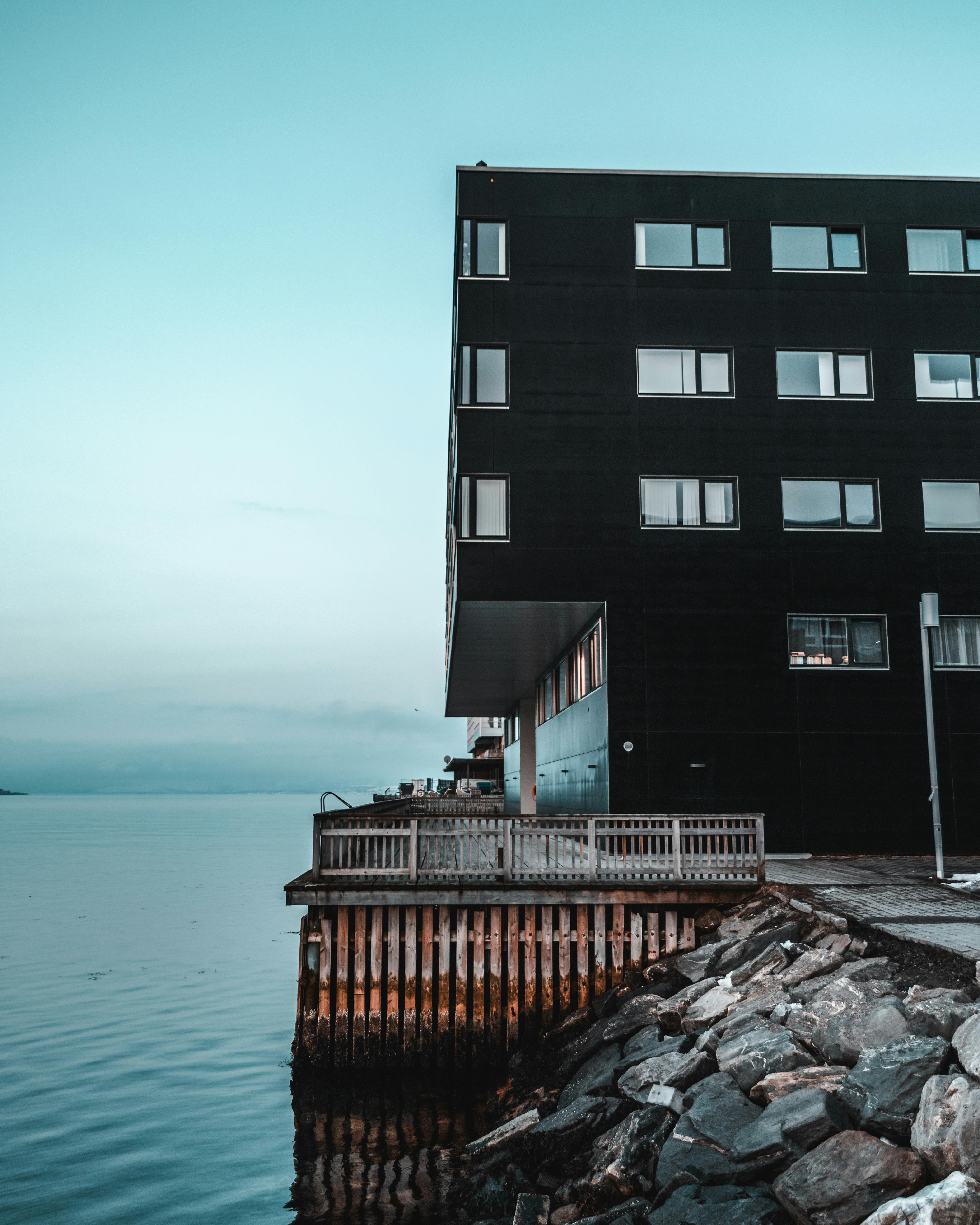 在岩石海岸上，矗立着一座俯瞰平静大海的现代建筑，其建筑设计独具特色