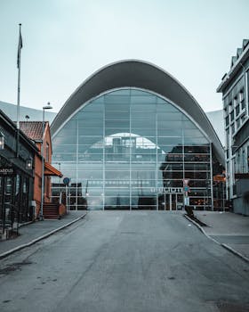 现代图书馆拥有拱形玻璃立面，其建筑设计时尚，位于城市环境中