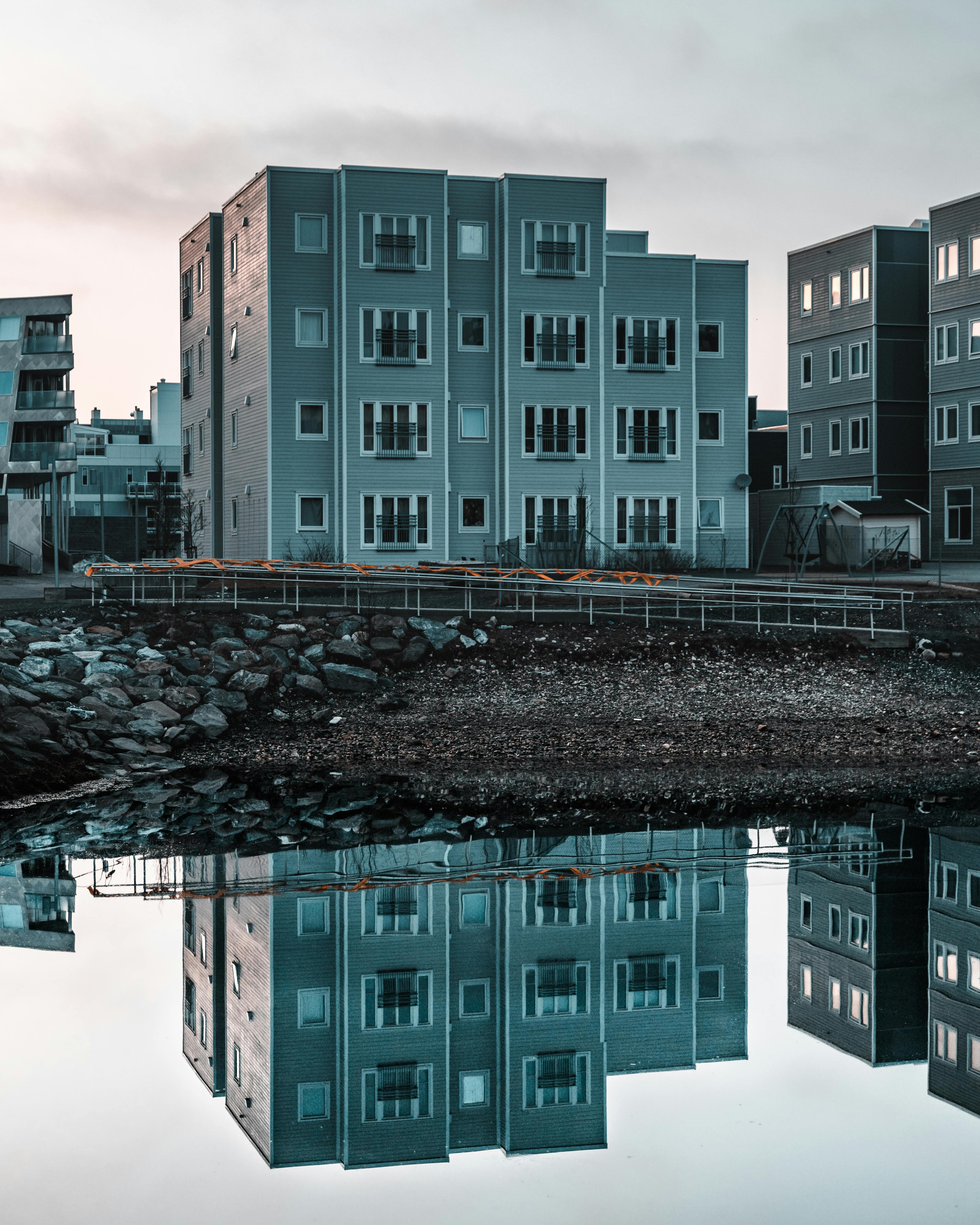 现代公寓楼倒映在平静的水面上，展现了现代城市设计的魅力