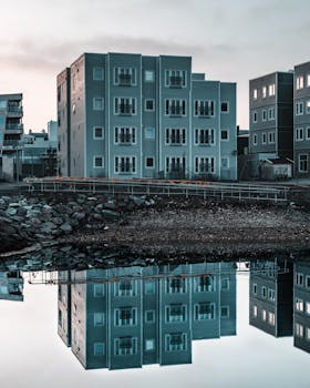 现代公寓楼倒映在平静的水面上，展现了现代城市设计的魅力