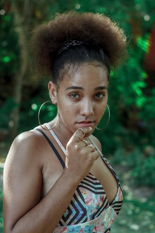 Photo of Woman in Multicolored Top and Silver-colored Hoop Earrings Posing