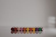 一排彩色蜡笔整齐地映照在闪亮的白色表面上，展现出简约的活力