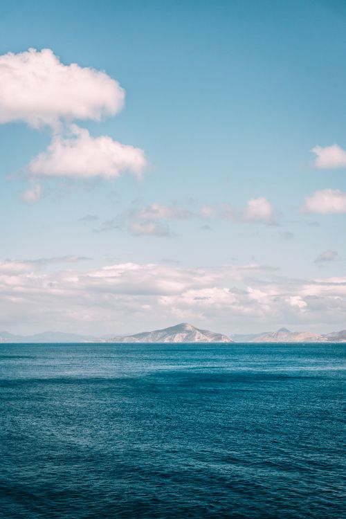 Ocean In The Distance A view of the ocean with a small island in the distance · Free Stock Photo