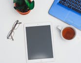 现代化工作空间配备了平板电脑和笔记本电脑，并备有一杯茶，以支持高效的工作会议