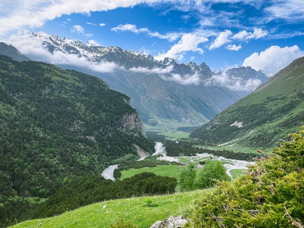 A scenic view of a valley with mountains and grass