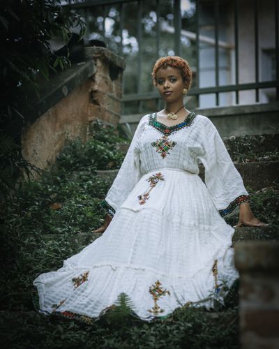 Young Woman in Traditional Clothing Sitting on the Grass · Free Stock Photo