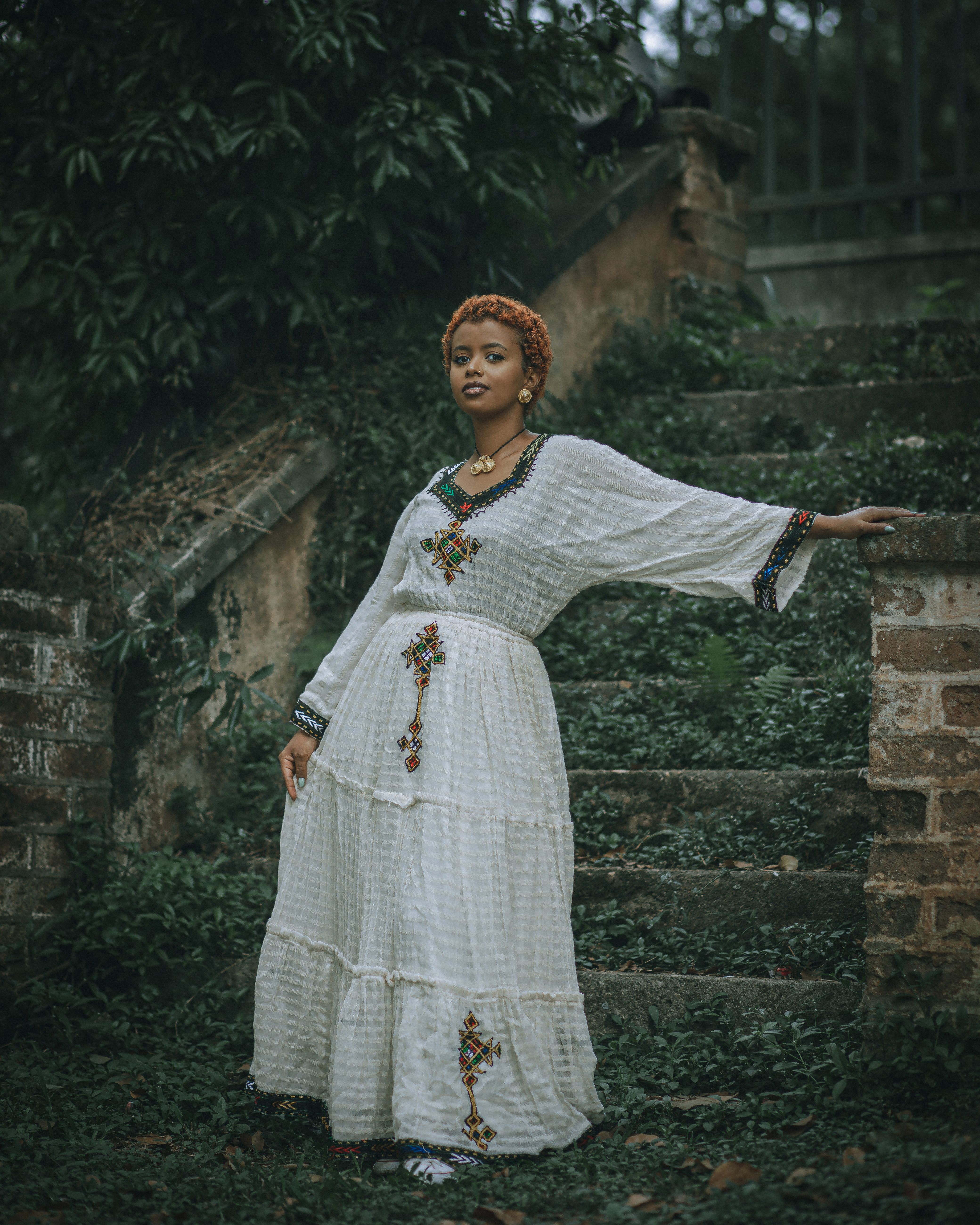 A Woman in a Long, White Dress Posing by the Stairs · Free Stock Photo