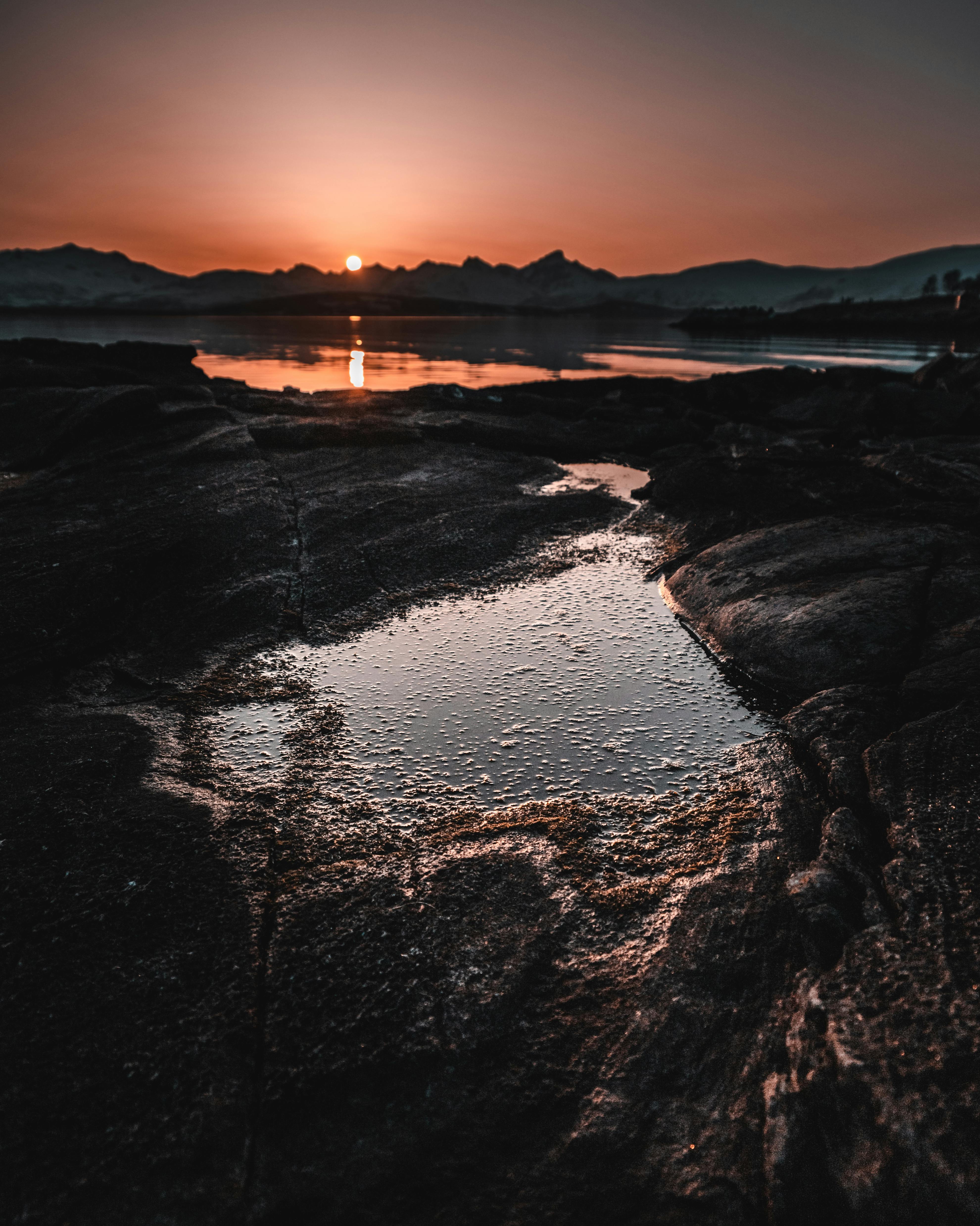 岩石海岸线上倒映着令人惊叹的日落，鲜艳的色彩与宁静的自然被完美捕捉