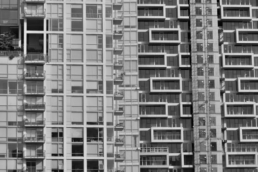 Black and white image of modern skyscraper facades in Vancouver, BC showcasing urban architecture.