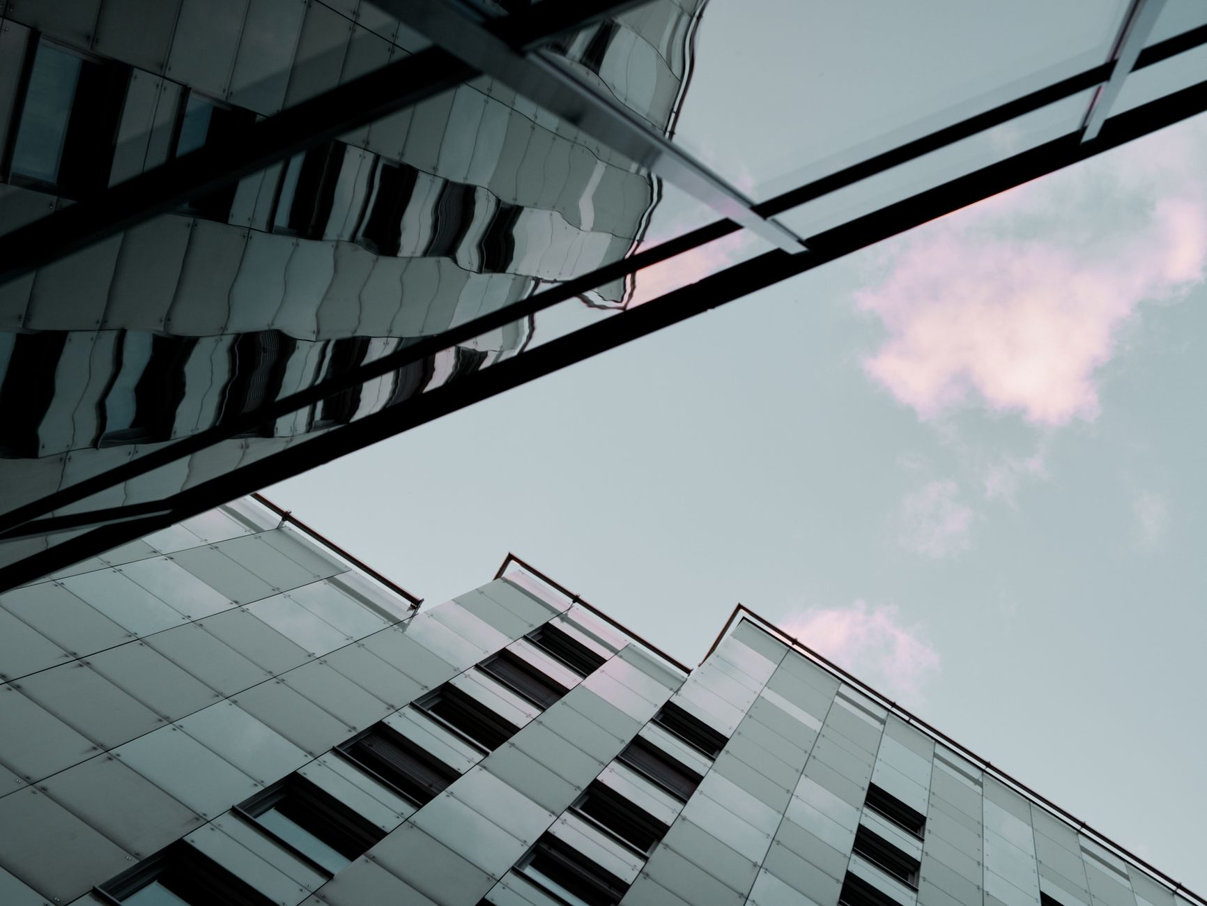 View of modern buildings with glass facades and reflections under a blue sky in Bratislava.