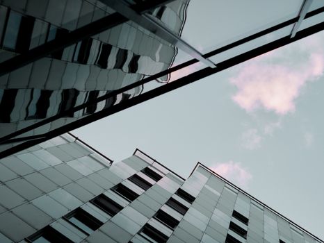 View of modern buildings with glass facades and reflections under a blue sky in Bratislava.