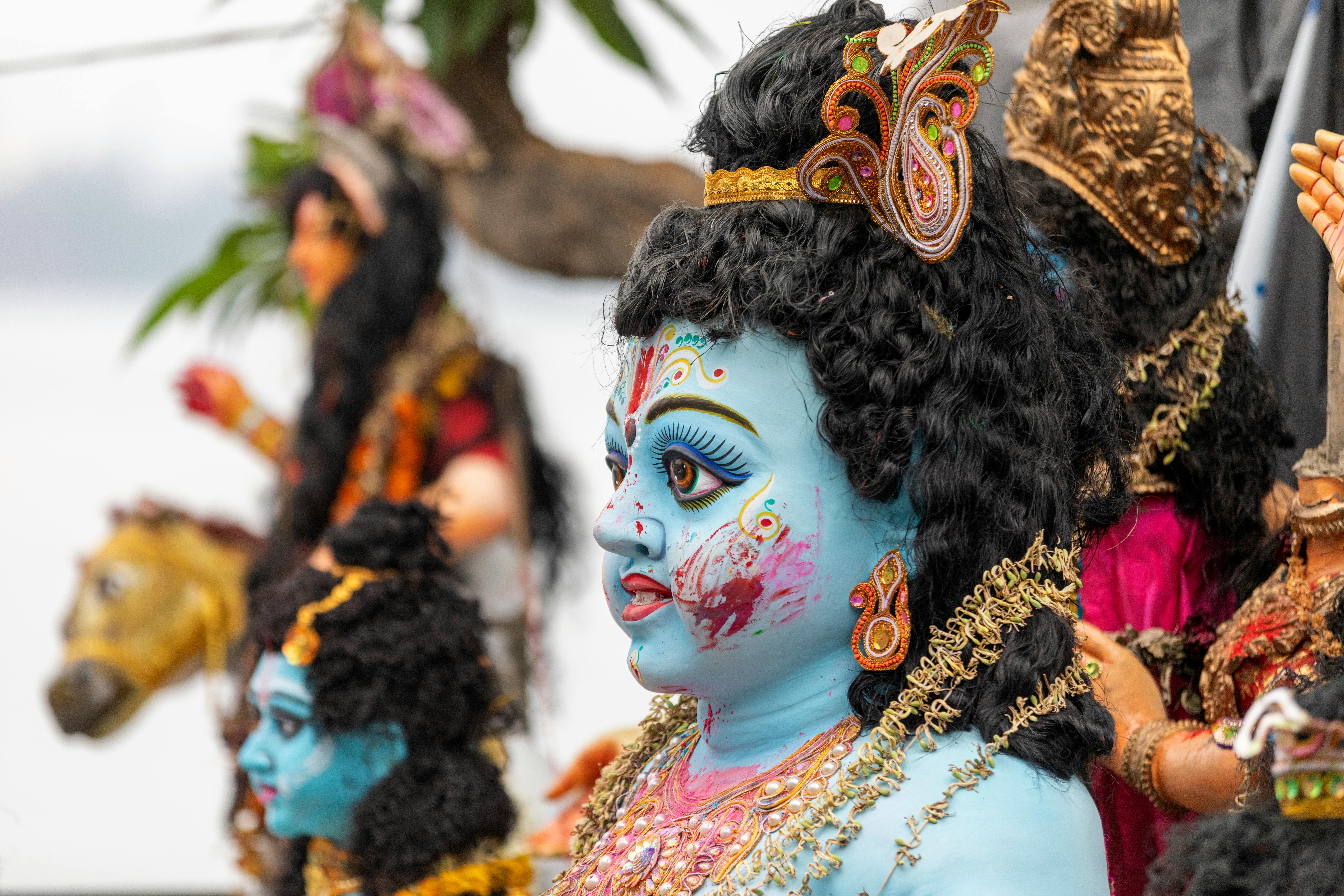 A statue of a god with blue and gold paint