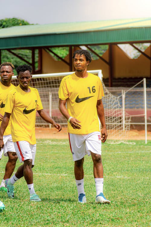 A group of men in yellow shirts playing soccer