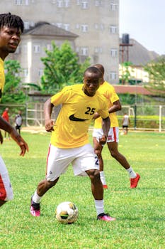 Group of soccer players in vibrant jerseys playing an intense match outdoors.