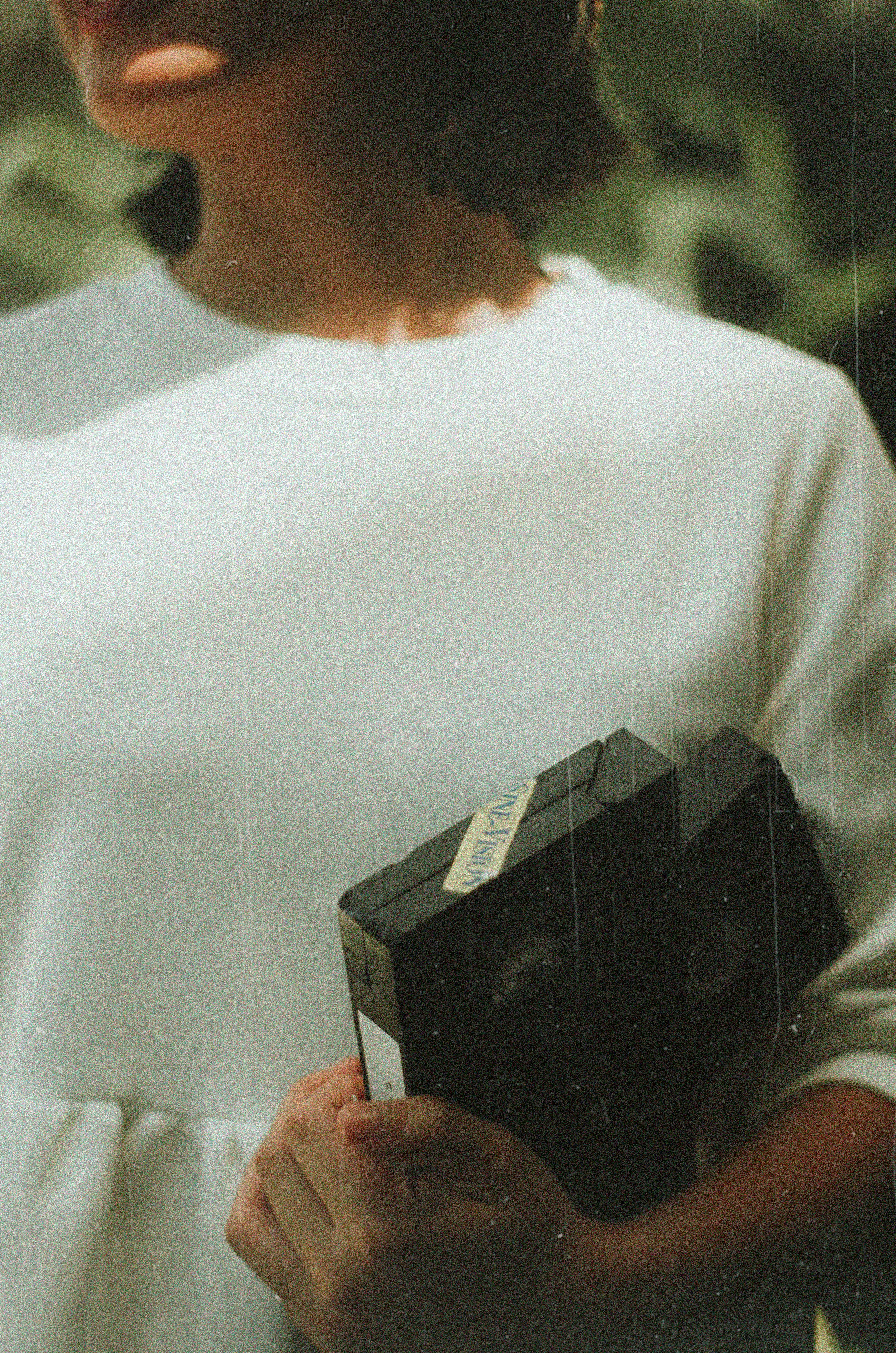 woman holding black vhs tape