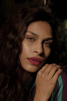 一位女性的特写肖像展现了自然的美丽与优雅的姿势，突出了她生动的嘴唇