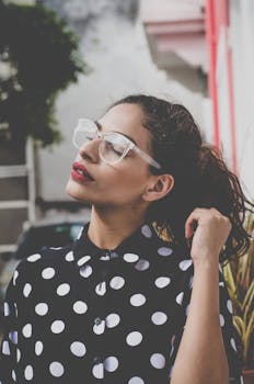 一位穿着圆点衬衫、戴着眼镜的女人在户外享受着阳光明媚的一天