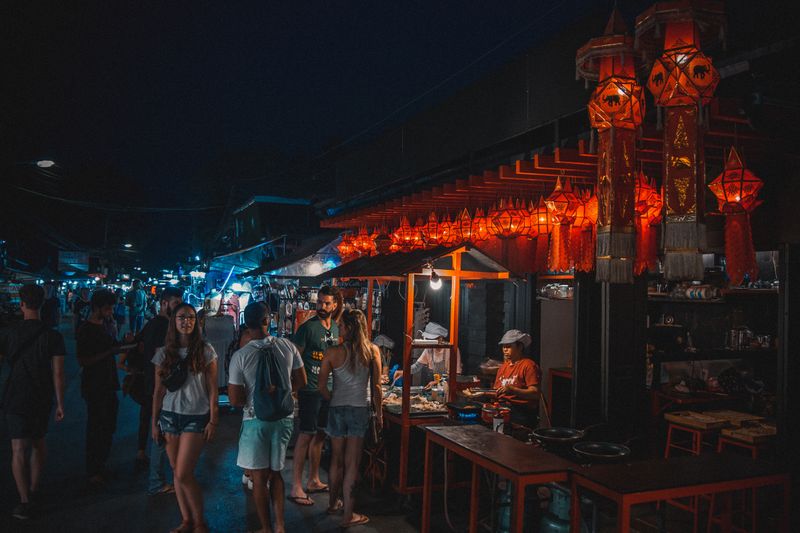 A lit night market street lined with food stalls