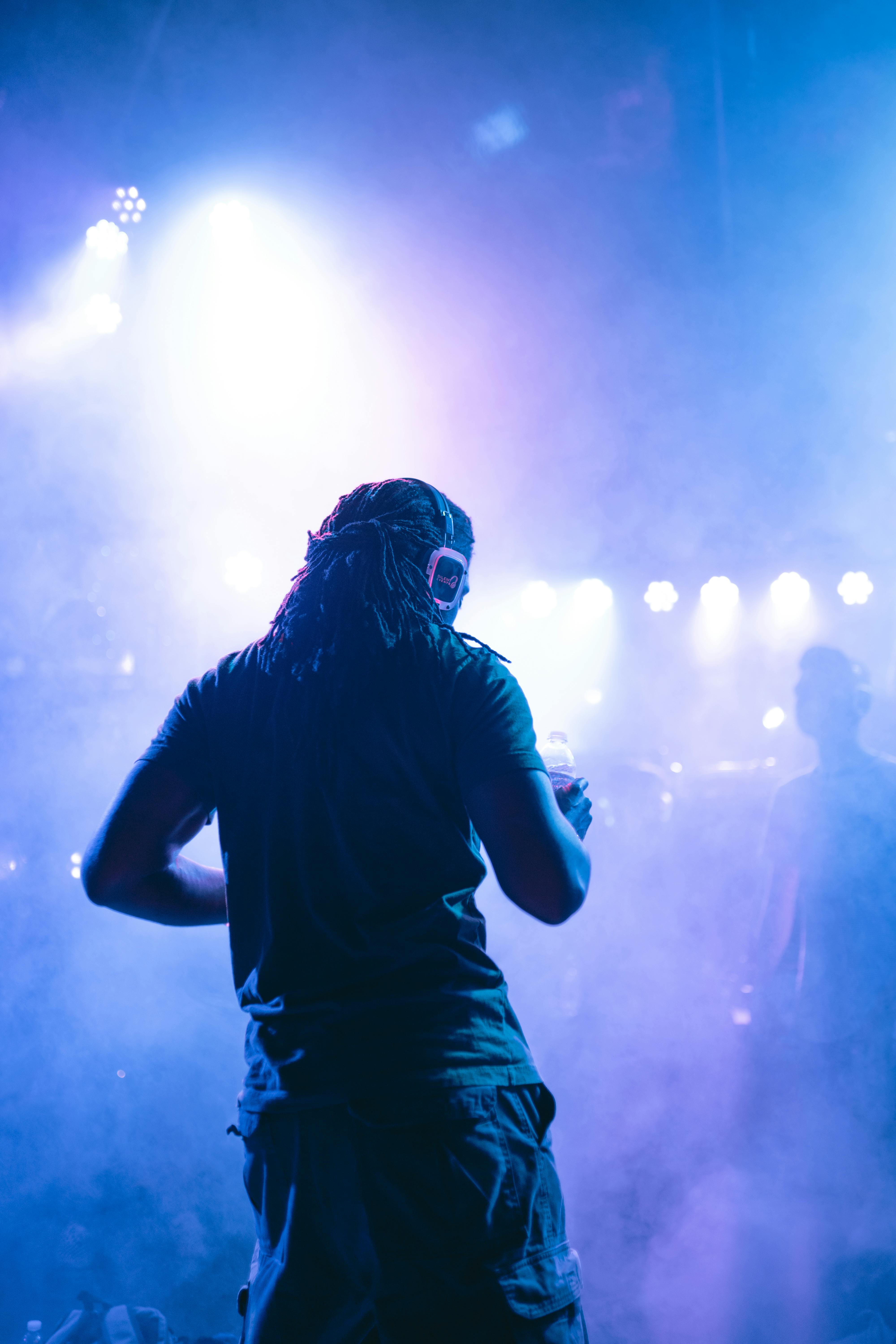 man wearing gray shirt performing on stage