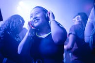 戴着耳机的女人在色彩缤纷、灯光充满活力的无声迪斯科舞厅中享受着