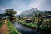 迷人的小山村以宁静的河流、郁郁葱葱的绿化和雄伟的山脉为背景，景色宜人