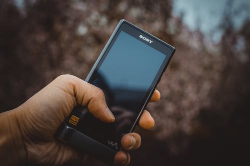 Person Hält Schwarzes Sony Smartphone