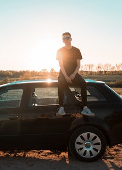 莱茵斯堡的年轻人坐在车顶，享受着宁静的日落