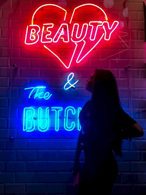 Woman Standing Near Red and Blue Neon Light Signage