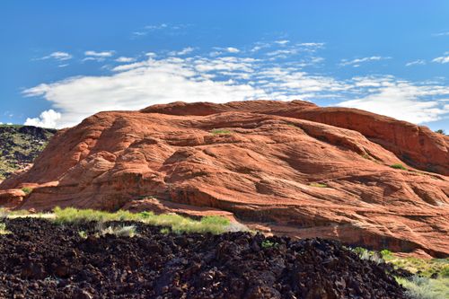 Free Beautiful red rock landscape with cloud-dappled sky, perfect for nature and travel inspiration. Stock Photo