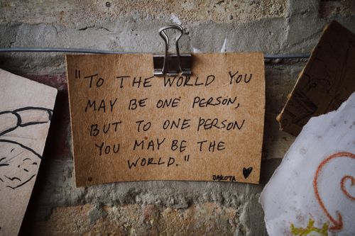 Free Handwritten inspirational quote on aged paper with a vintage feel, clipped to a textured brick wall. Stock Photo