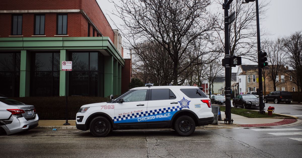 A Chicago police SUV parked on a city street near an intersection on a cloudy day.
