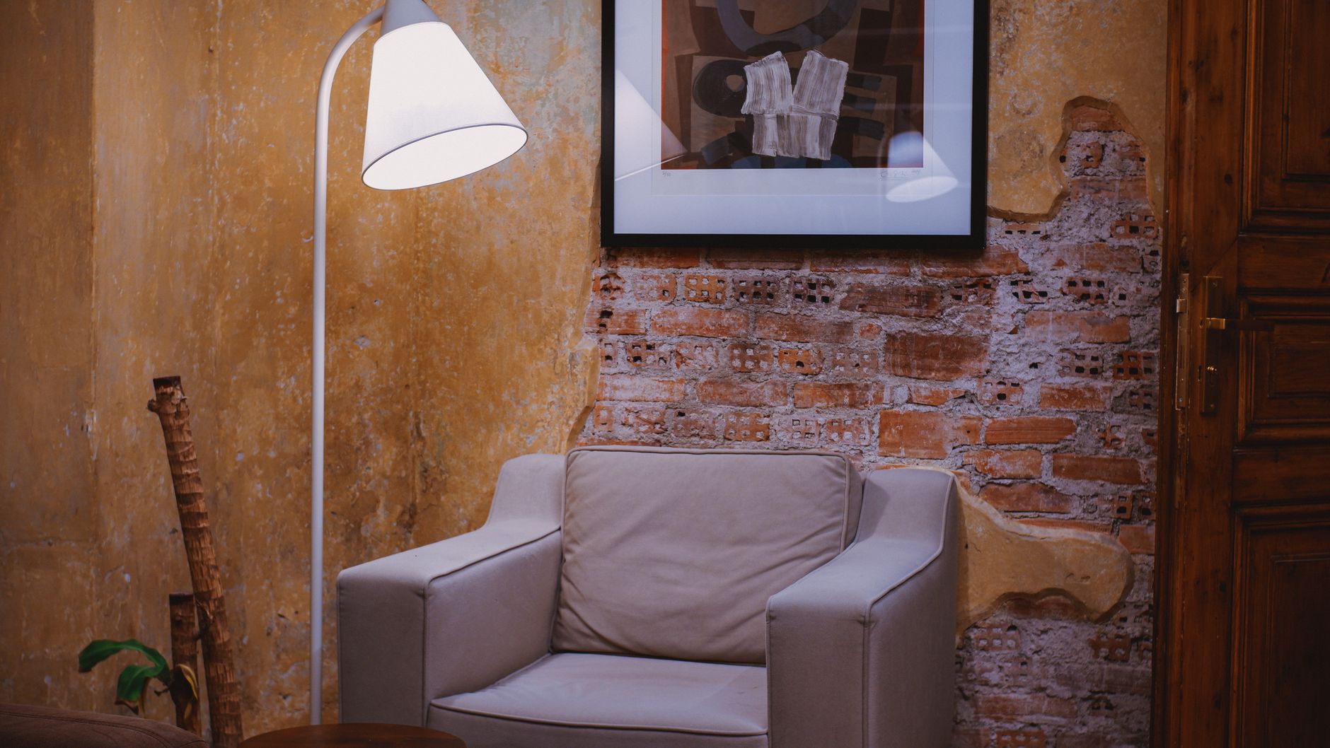 Un sillón y una lámpara de pie en un rincón