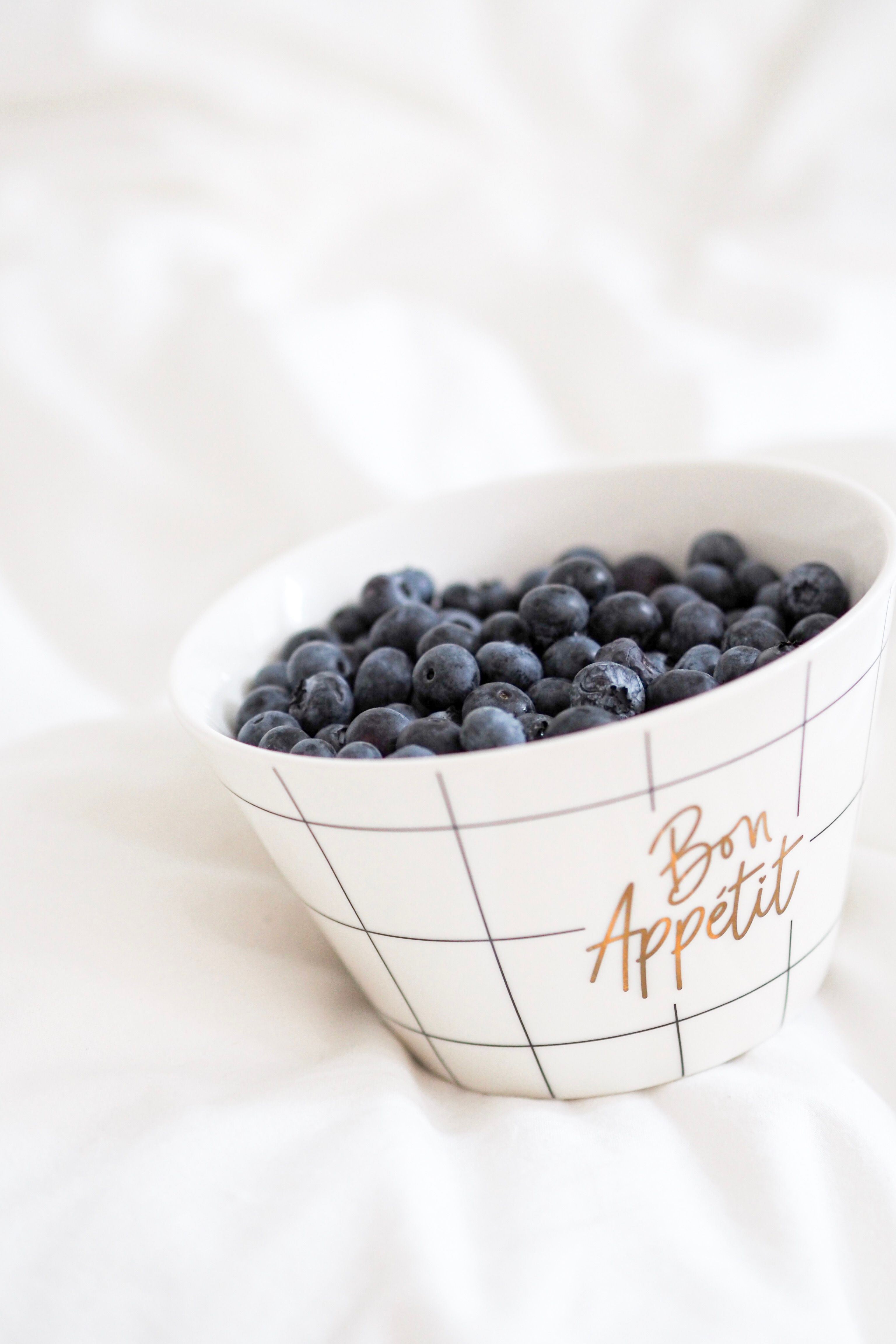 A bowl of fresh blueberries with 'Bon Appétit' printed, perfect for healthy eating.