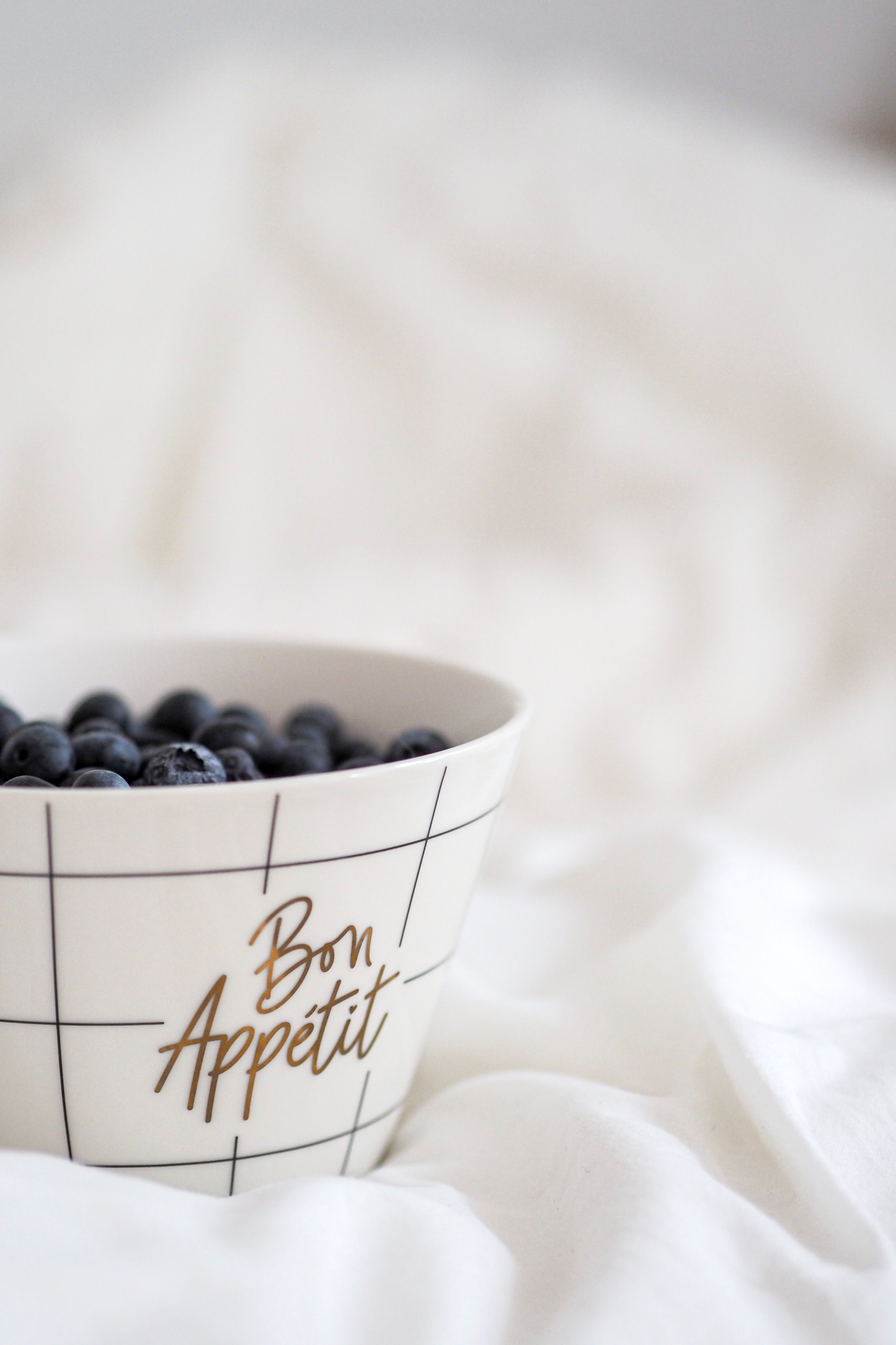 Aesthetic shot of a bowl with blueberries on white sheets. Perfect for healthy lifestyle promotion.