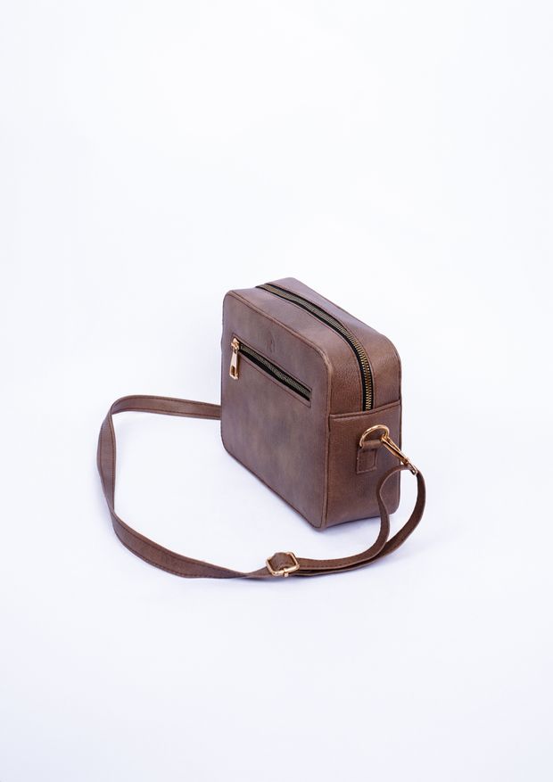 Brown leather crossbody bag on a white studio backdrop, photo by Muneeb Malhotra on Pexels