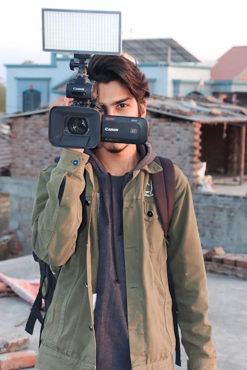 A man holding a camera in front of a building